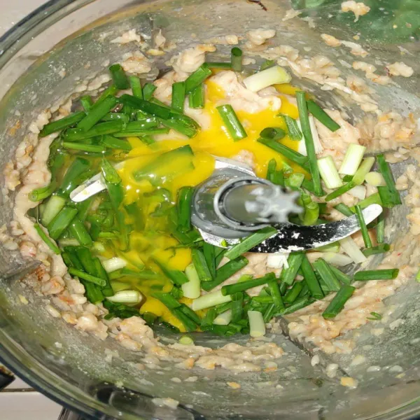 Masukkan telur dan daun bawang, lalu giling lagi sampai tercampur rata.