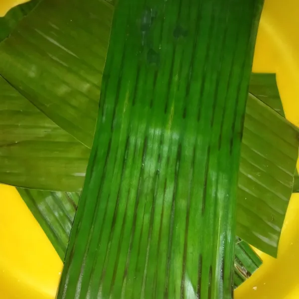 Siapkan daun pisang, saya layukan dulu daun pisang di atas api kompor agar pas dibentuk daun tidak mudah robek, jika tidak ada daun pisang gunakan cetakan kue talam atau putu ayu.