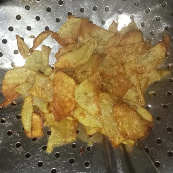 Kupas dan iris tipis kentang, lalu goreng hingga kering, angkat dan tiriskan.