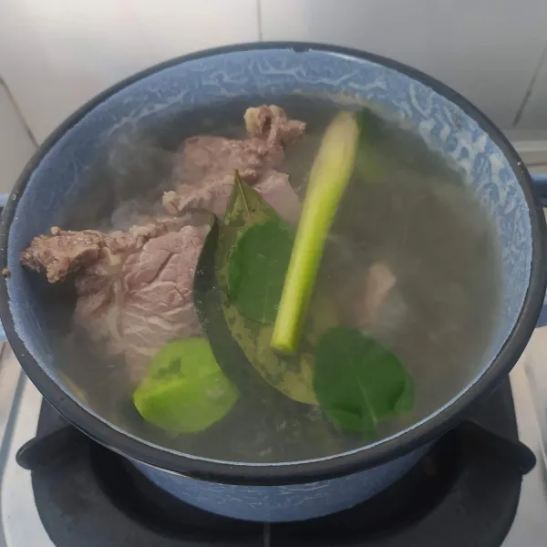 Rebus daging dengan air cucian beras sebanyak 700 ml bersama daun salam, daun jeruk purut dan serai geprek sampai empuk, kemudian potong kotak sesuai selera.