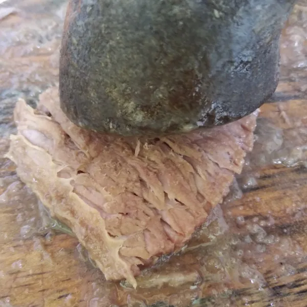 Angkat empal dan biarkan dingin kemudian pukul pukul daging dengan ulekan.