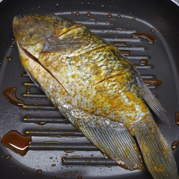 panaskan grillpan, beri olesan minyak goreng. panggang ikan yang sudah dimarinasi sampai daging berubah putih di kedua sisi.
