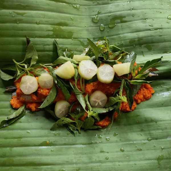 Campur bumbu halus dengan garam dan gula. Lumuri ikan salem dengan bumbu, letakkan di atas daun pisang. Di Atasnya diberi kemangi dan belimbing sayur.