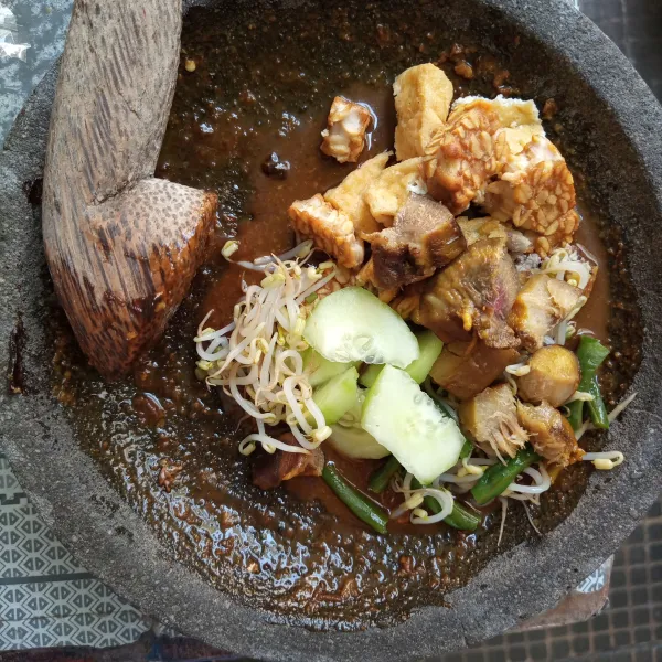 Masukkan semua isian rujak, aduk hingga semua isian tercampur rata dengan bumbu. Sajikan dengan kerupuk dan telur rebus.