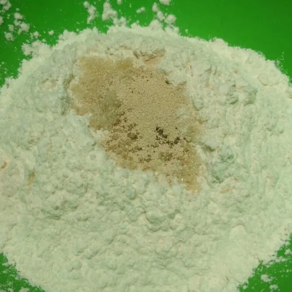 Dalam wadah campur tepung terigu, ragi instan, gula pasir dan garam, aduk rata.