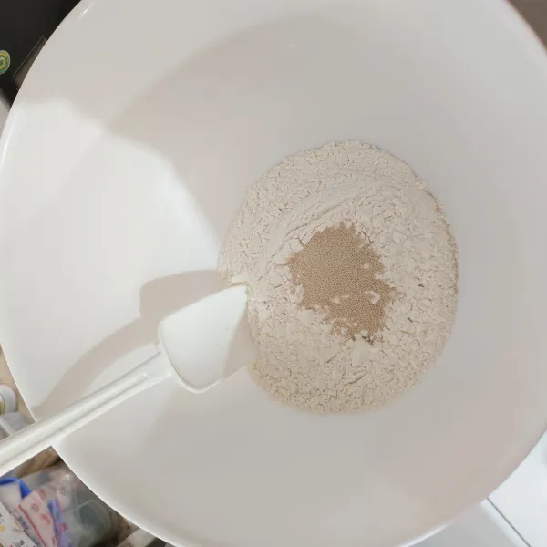 Ayak tepung terigu, selanjutnya masukan Ragi dan aduk hingga tercampur rata.
