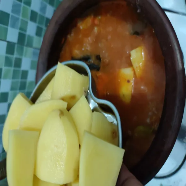 Jika daging sudah agak empuk, masukkan kentang. Aduk hingga rata.