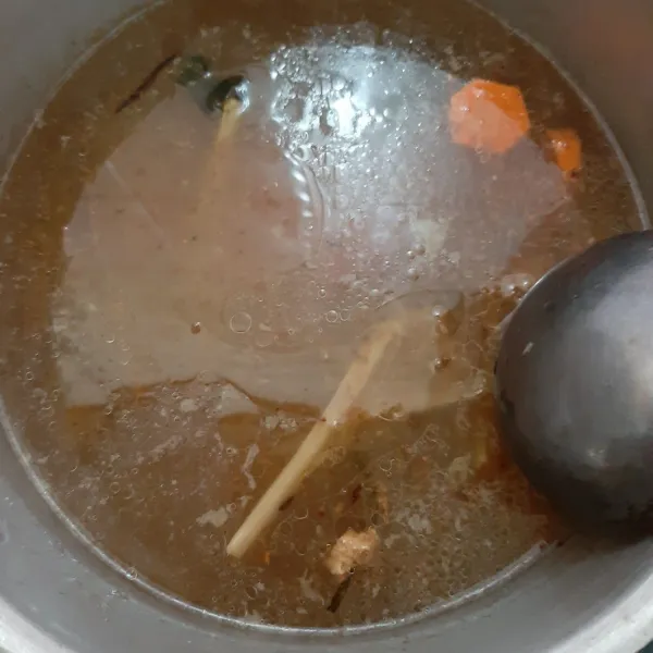 Masukkan tumisan bumbu dan wortel ke air rebusan ceker. Biarkan mendidih dan wortel lunak.