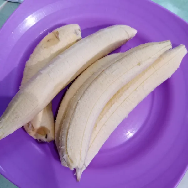 Kupas pisang lalu pipihkan agar sedikit gepeng.