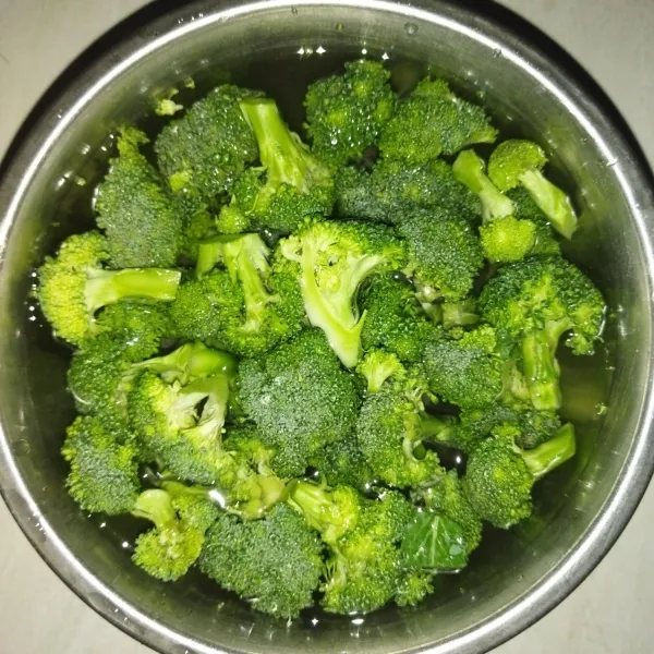 Siapkan brokoli, siangi petiki perkuntum, lalu siapkan mangkuk dan beri air secukupnya. Masukkan sekitar 1 sdm garam, lalu rendam brokoli selama 10 menit.