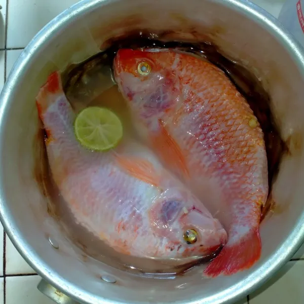 Bersihkan ikan, belah punggung ikan, jangan sampai terputus. Lalu rendam dengan air  dan perasan jeruk nipis selama 10 menit.
