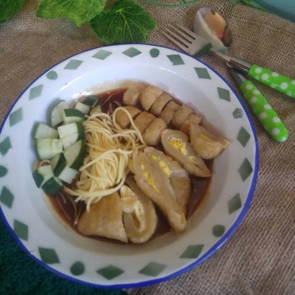 Potong-potong pempek, beri irisan mentimun dan mie lalu siram dengan kuah cuko. Sajikan.