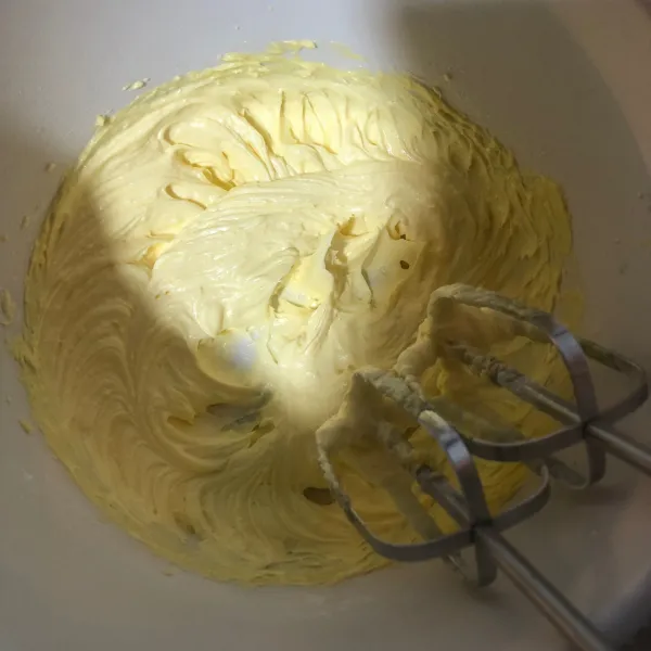 Buat adonan dasar dengan kocok margarin, unsalted butter, dan gula halus dengan mixer kecepatan rendah.