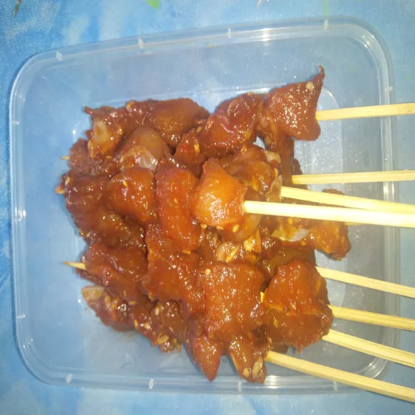 Setelah dikeluarkan dari kulkas, tusukkan dalam tusuk sate sekitar 4-5 potong di setiap tusukan sate. Simpan bumbu sisa marinasi.
