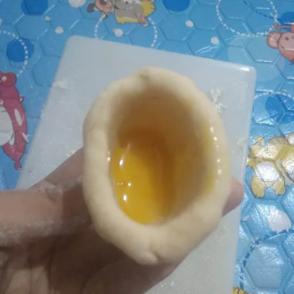 Ambil sedikit adonan lalu bentuk cekung, isi dengan telur kocok untuk membuat pempek kapal selam. Jangan terlalu penuh mengisinya. Rapatkan bagian atasnya.