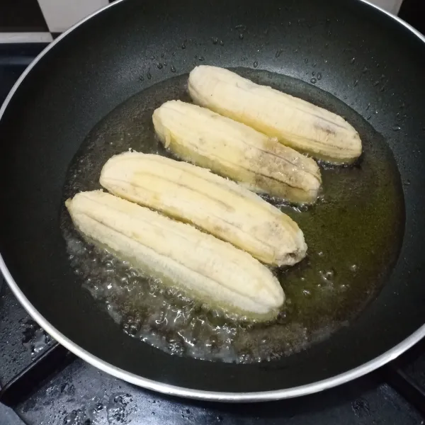 Kupas pisang lalu goreng sampai matang.