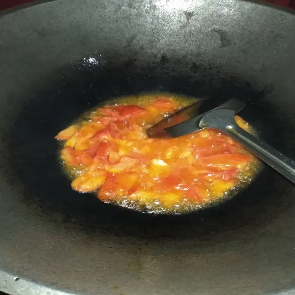 Panaskan minyak goreng secukupnya. Tumis tomat yang telah diiris hingga layu. Masukkan bumbu halus, tumis hingga harum.