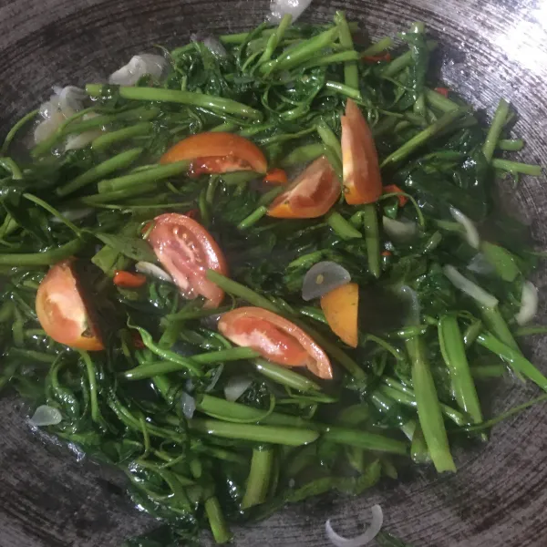 Masukkan irisan tomat dan masak hingga kangkung matang dan air agak menyusut. Koreksi rasa, angkat dan sajikan.