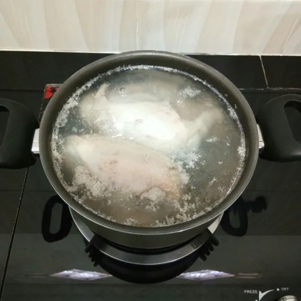 Rebus ayam dengan secukupnya air hingga mendidih, lalu tiriskan ayam dan buang air rebusannya.