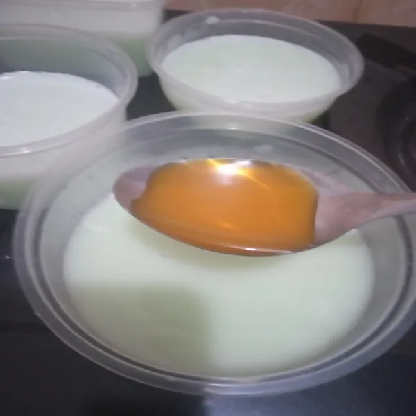 Beri masing-masing 1 sdm sirup jeruk pada setiap cup, kemudian diamkan hingga mengeras. Puding siap disajikan.