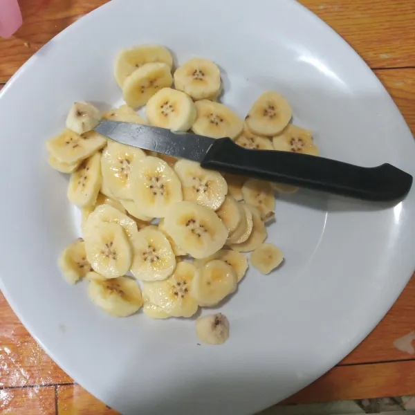Kupas pisang lalu potong kecil tipis.
