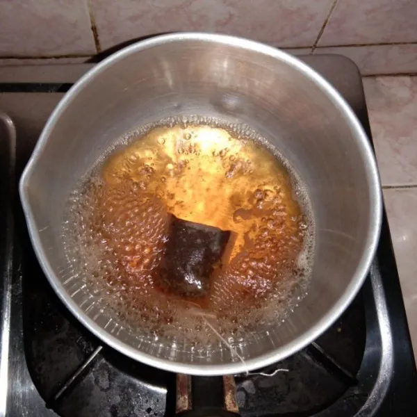Nyalakan kompor, lalu seduh kantung teh di dalam panci dengan air panas.