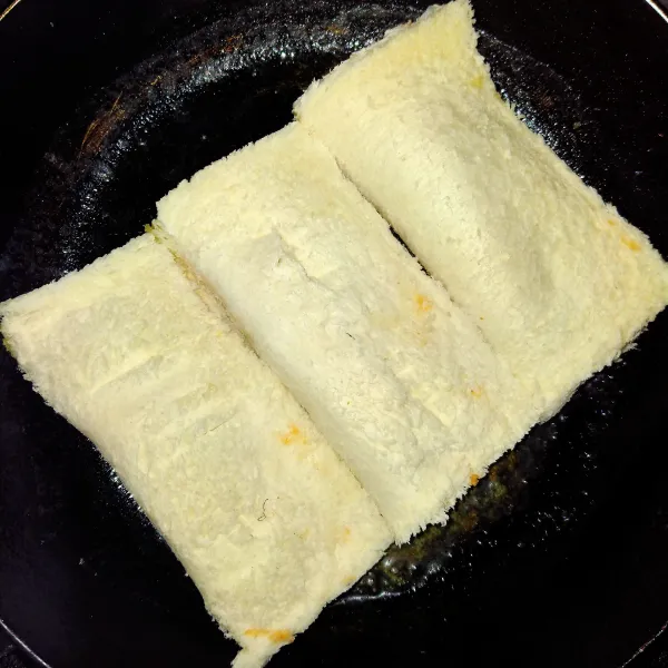 Tutup menggunakan garpu lalu panaskan teflon yang telah diberi mentega. Masukkan roti tawar panggang hingga berubah warna.