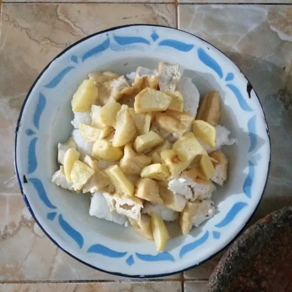 Siapkan piring saji. Beri potongan lontong, tahu goreng dan kentang goreng.