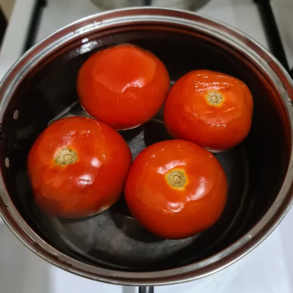 Rebus tomat hingga lunak, biarkan dingin. Lalu kupas kulitnya dan blender.
