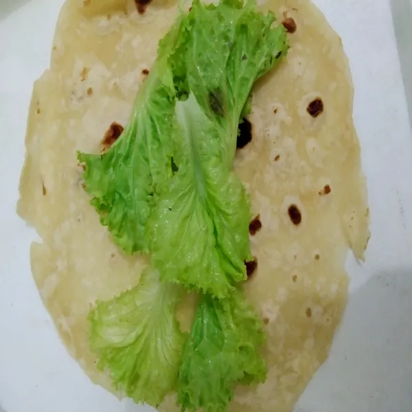 Ambil satu lembar Tortilla dan letakkan daun selada.
