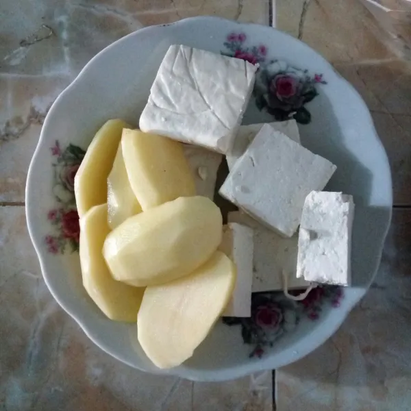 Potong tahu jadi beberapa bagian. Potong juga kentang agak tipis.