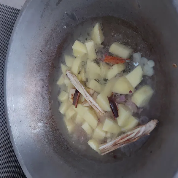 Masukkan kentang, air, kayu manis, jahe dan sereh. Masak sampai kentang empuk.