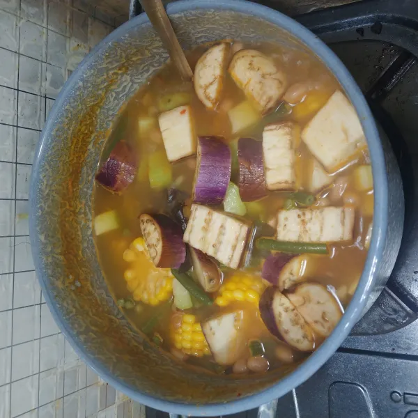 Setelah sayuran cukup matang, masukkan terong ungu dan bumbui dengan gula, garam, kaldu bubuk dan gula pasir. Aduk hingga rata. Koreksi rasanya.
