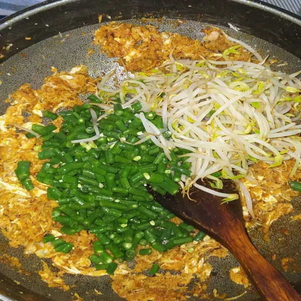 Masukkan kacang panjang, tauge dan irisan daun jeruk. Aduk kembali hingga tercampur rata.