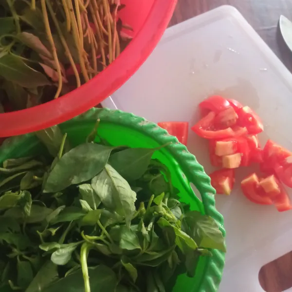 Petik daun kemangi, potong dadu tomat dan rajang daun bawang