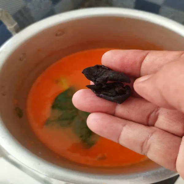 Campur bumbu halus dan air, tambahkan asam kandis, daun ruku-ruku, lengkuas, serai, dan daun jeruk. Aduk rata.