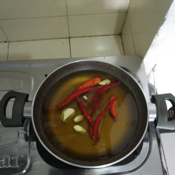 Goreng bawang putih dan cabai dalam minyak panas.