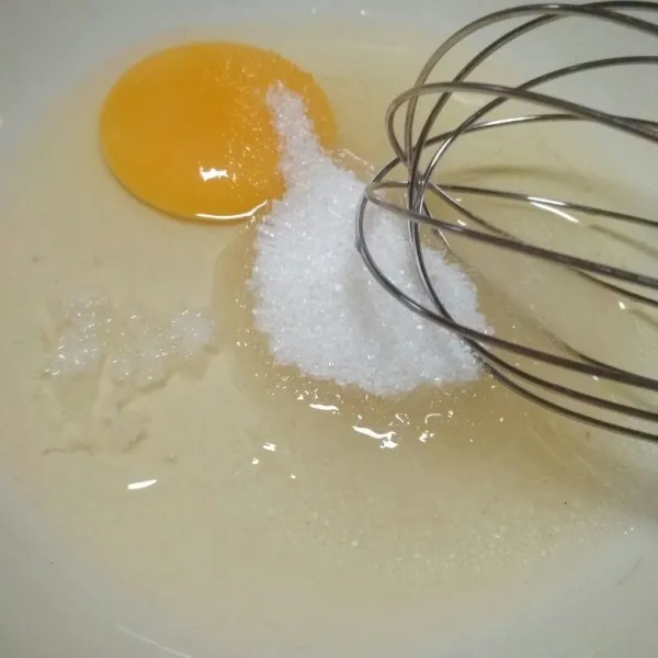 Dalam wadah campur telur, gula pasir, garam dan sejumput pasta susu kocok hingga tercampur rata.