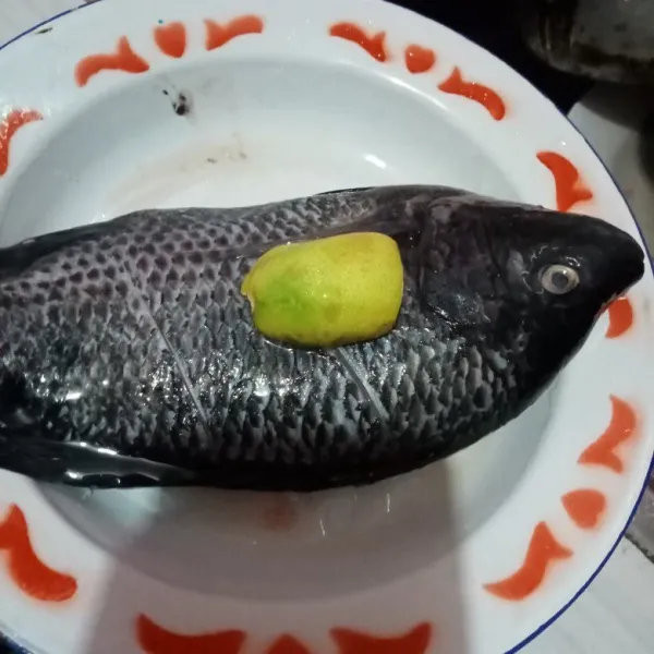 Berrsihkan ikan dengan membuang kotoran di dalam perut Ikan, buang juga sisik kulit Ikan, cuci bersih kemudian lumuri perasan jeruk lemon.