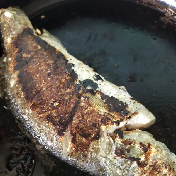 Panaskan pan anti panas dan beri minyak. Bakar ikan hingga matang.