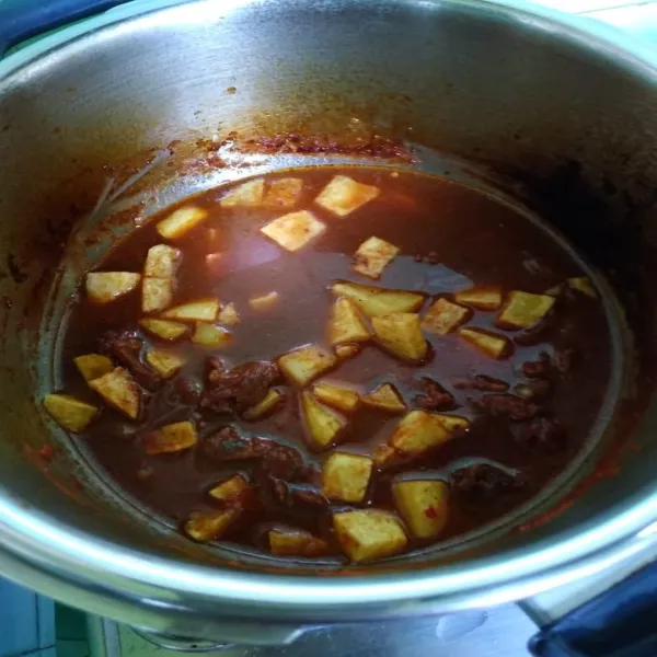 Setelah daging empuk, masukkan kentang, masak sampai meresap. Koreksi rasa, siap dihidangkan.