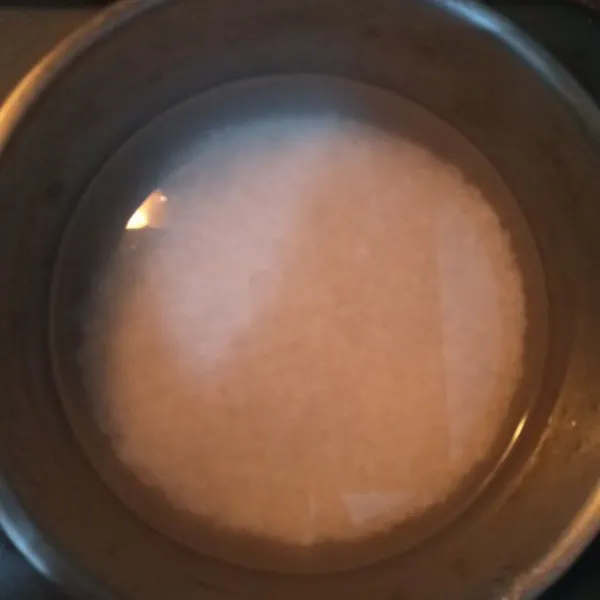 Cuci bersih beras, beri air agak banyak dan rebus hingga beras menjadi nasi, aduk terus hingga menjadi bubur.
