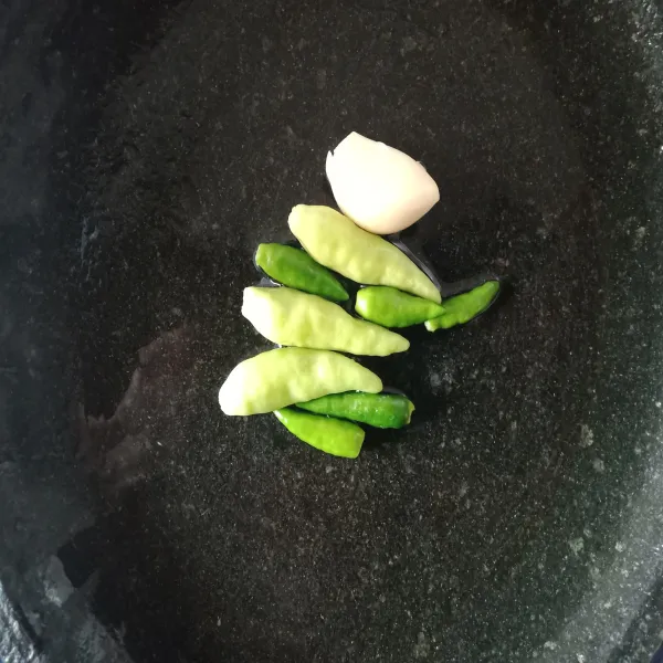 Buat cuko dengan haluskan cabai dan bawang putih, sisakan dua cabai rawit utuh.