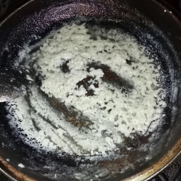 Membuat lalaan (endapan santan rebus) dengan masak santan dan garam hingga santan kering dan berminyak seperti gambar di atas.