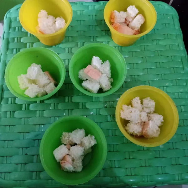 Potong kecil roti tawar. Masukkan ke dalam cetakan.