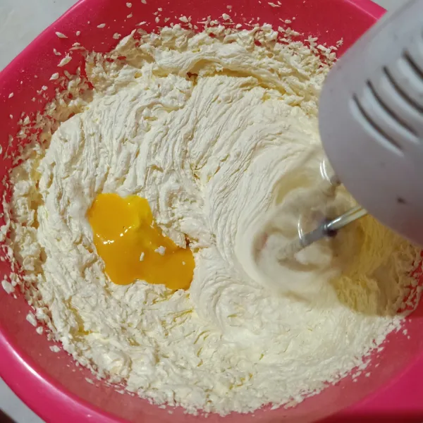 Tetap dengan kecepatan tinggi, masukkan kuning telur satu persatu sambil di mix sampai homogen.