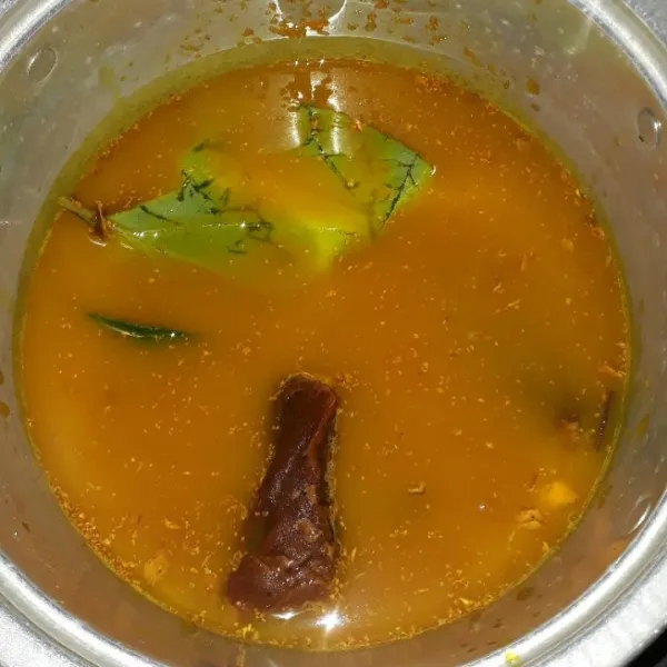 Dalam panci, masukkan kunyit yang telah diparut, gula merah, gula jawa, garam, asam, daun sirih yang telah diremas, dan air.