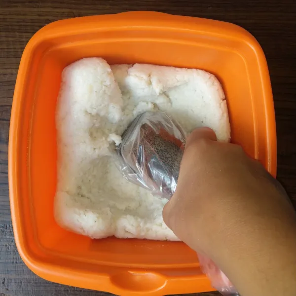 Selagi hangat tumbuk nasi menggunakan uleg yang dilapisi plastik di dalam baskom kotak sampai padat lalu ratakan permukaanya. Tunggu dingin.