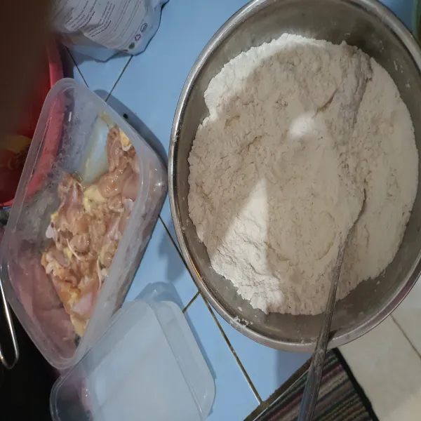 Siapkan bahan pelapis, kemudian ambil 1 potong ayam, masukkan ke dalam bahan pelapis, celupkan ke dalam air es, lalu balurkan lagi ke dalam adonan pelapis sambil ditekan-tekan.