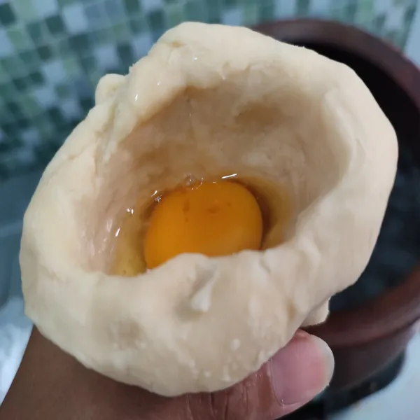Pecahkan telur dan simpah dalam wadah, pisahkan setengah bagian putih telurnya karena jika putih telur digunakan semua, isian akan penuh dan keluar dari adonan pempek. Ambil adonan, bulat-bulatkan kemudian lubangi tengahnya dan di pipihkan bagian atasnya.Iisi dengan telur. kemudian rekatkan bagian atasnya. Lakukan berulang sampai bahan habis.